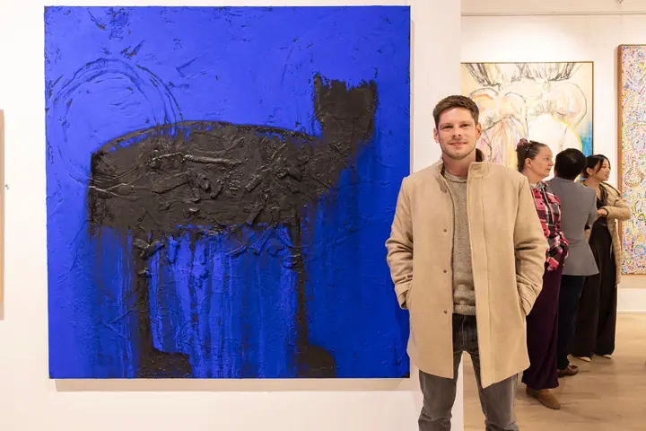 A visitor beside a large blue work