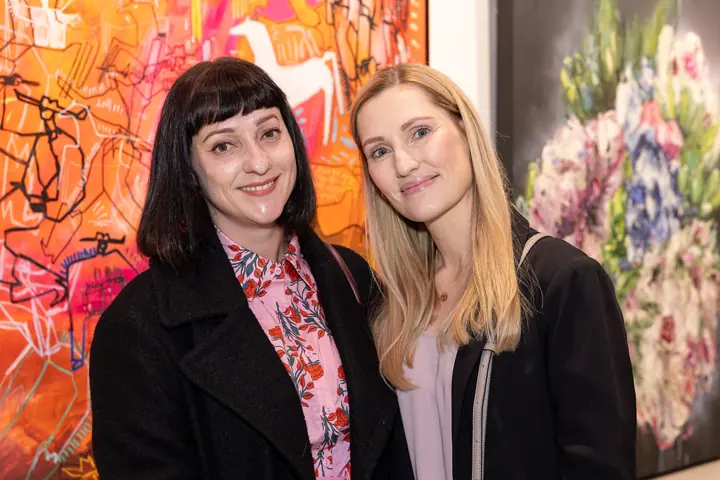 Two guests in front of an orange painting